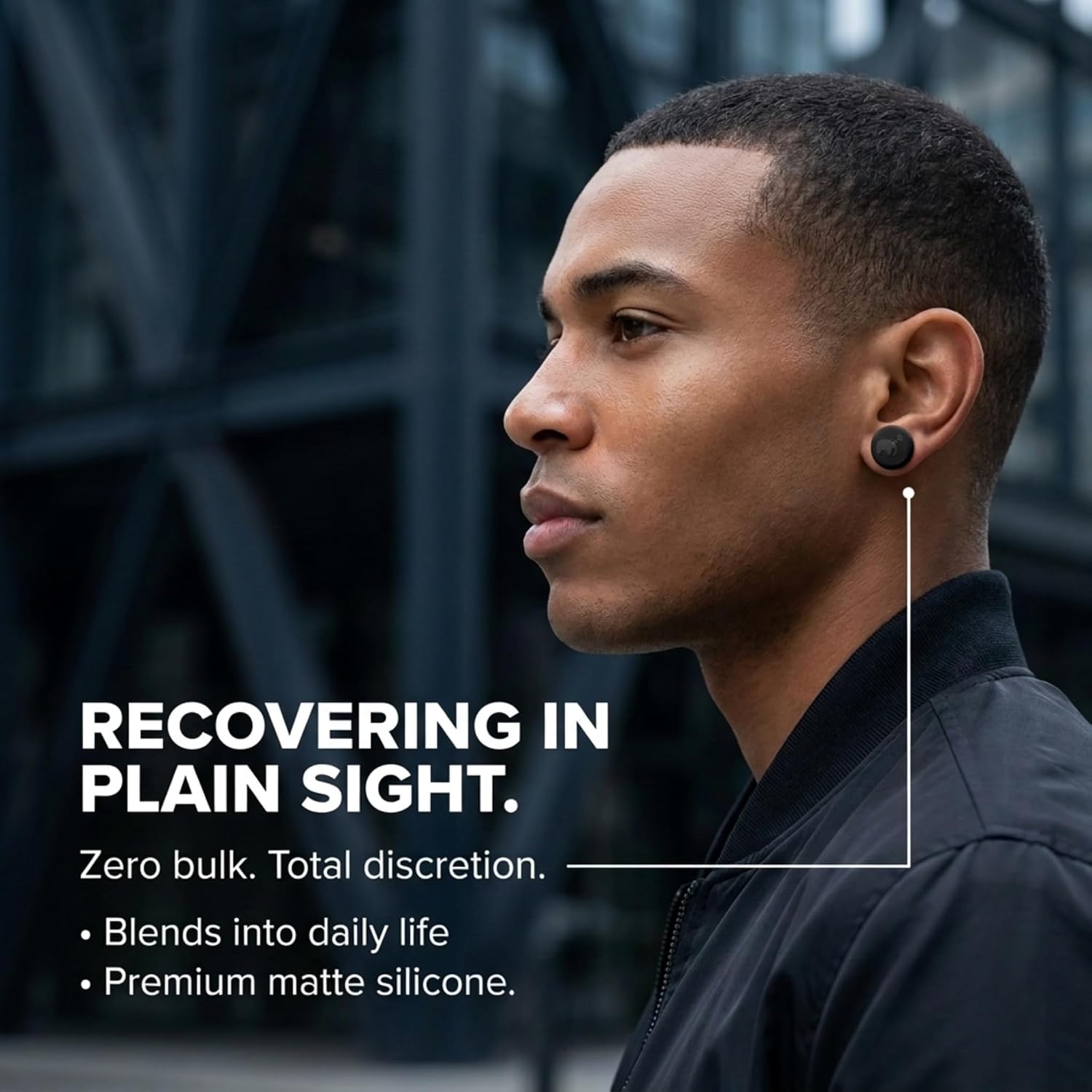 A man wearing a black disc on his earlobe